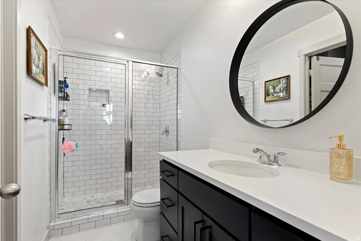 Full bath with vanity, a shower stall, and recessed lighting