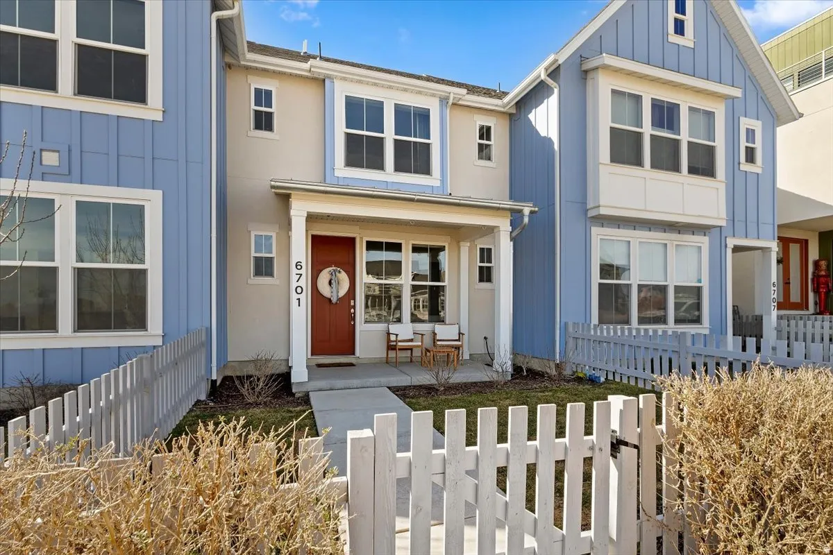 View of front facade featuring board and batten siding, covered porch, and a fenced front yard