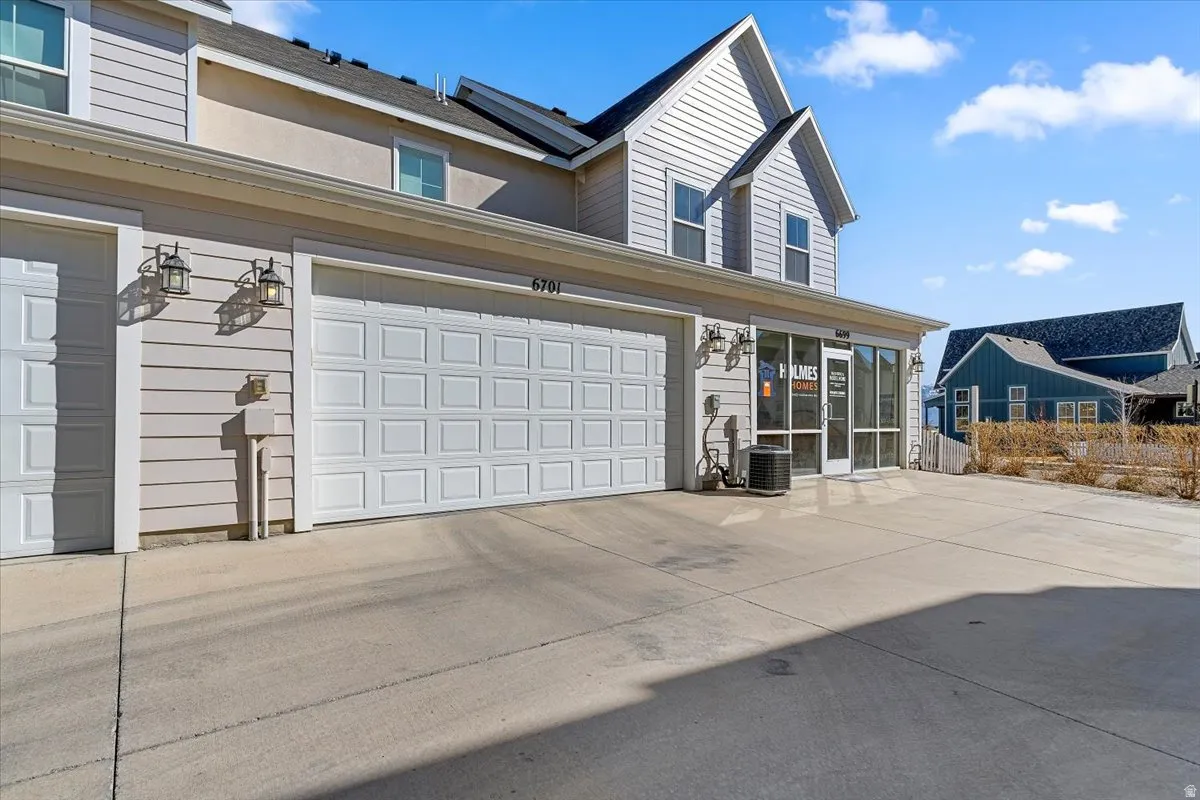 View of front facade featuring concrete driveway and a sunroom