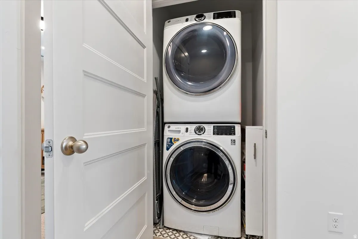 Laundry area with stacked washer and clothes dryer