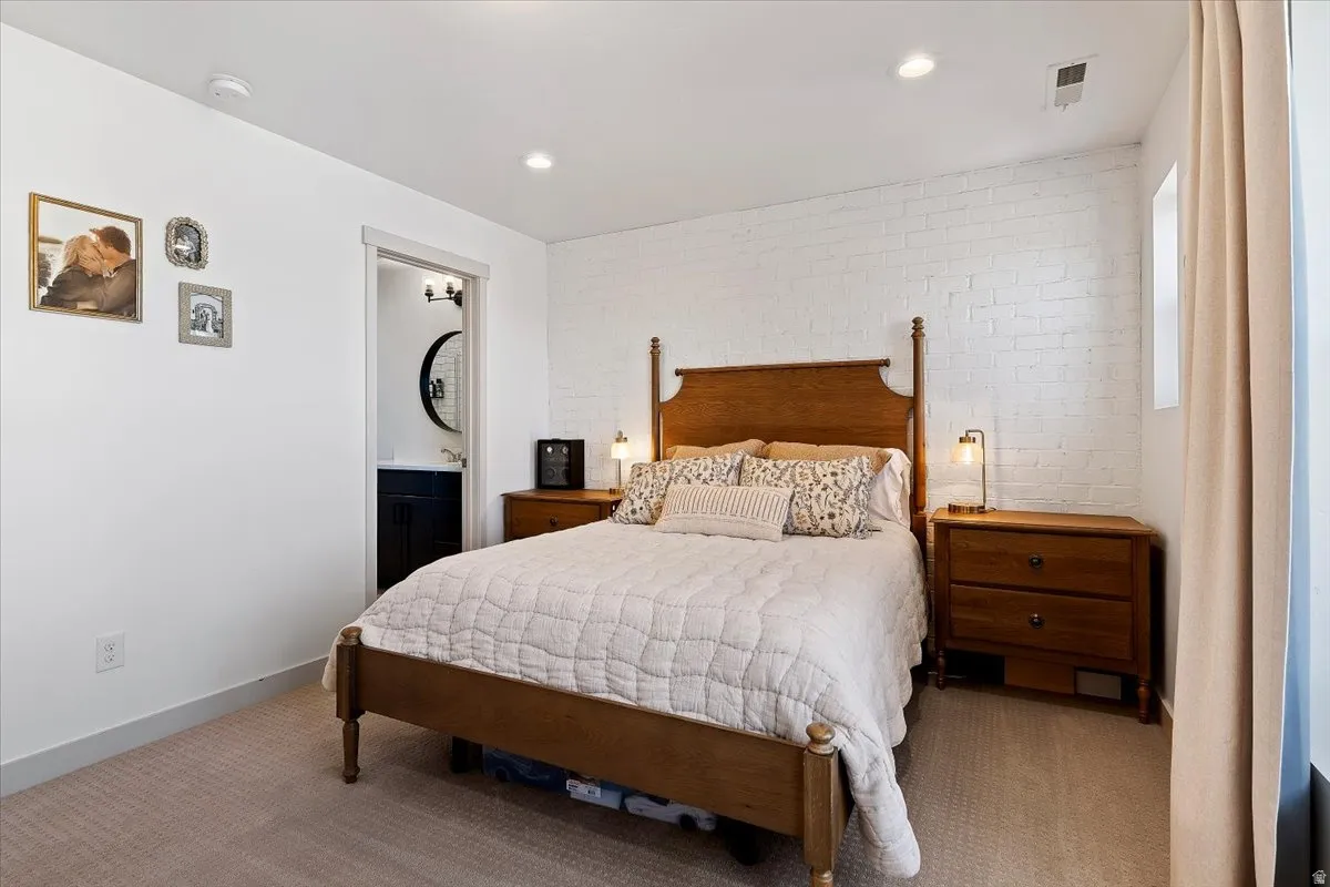 Bedroom featuring brick wall, carpet flooring, and recessed lighting