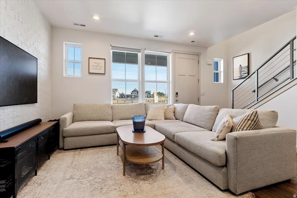 Living area featuring brick wall and recessed lighting