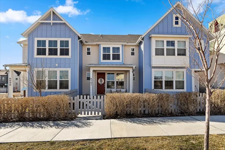 Craftsman house with board and batten siding, a fenced front yard, and a gate