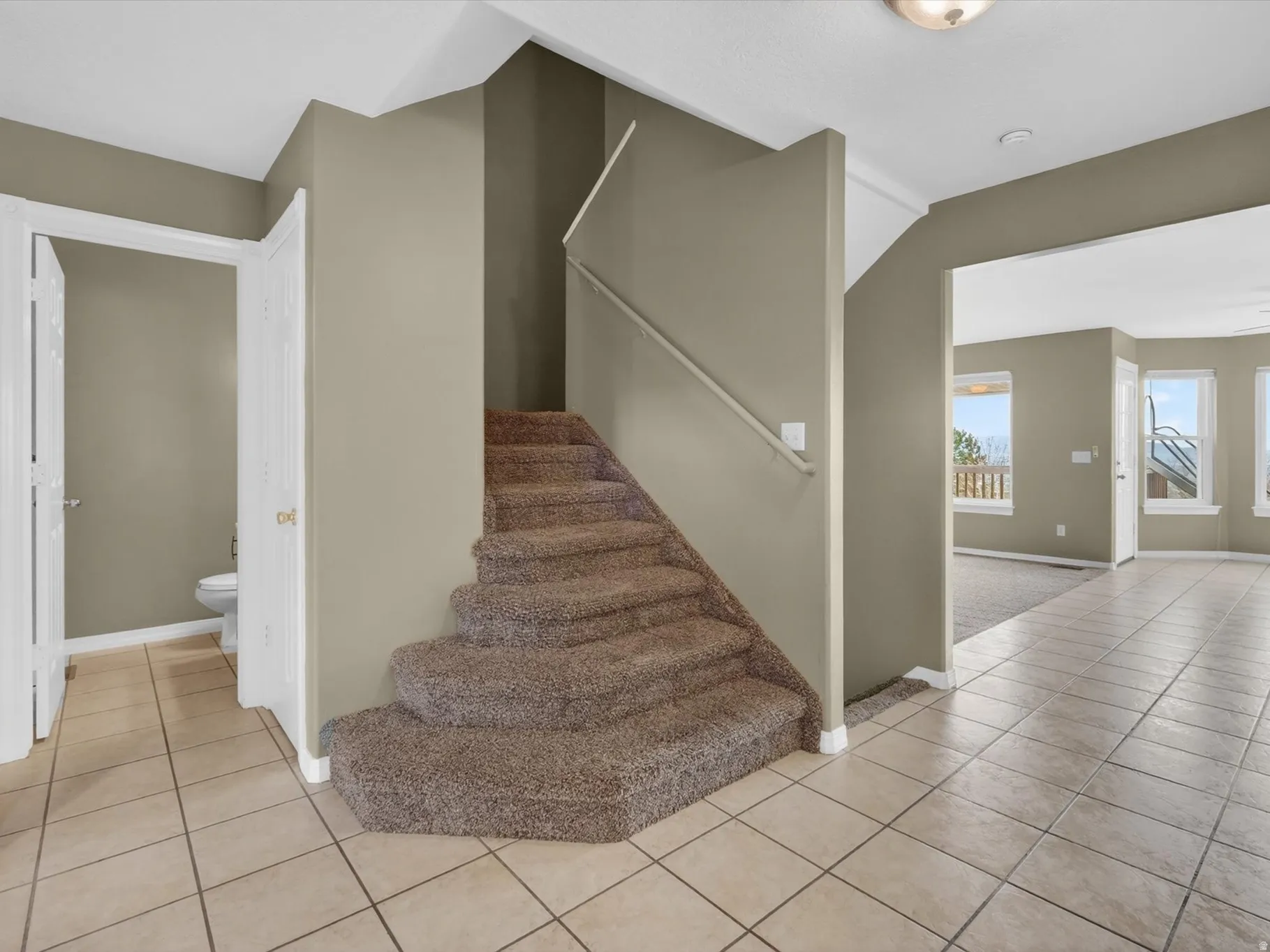 Staircase featuring tile patterned flooring and a ceiling fan