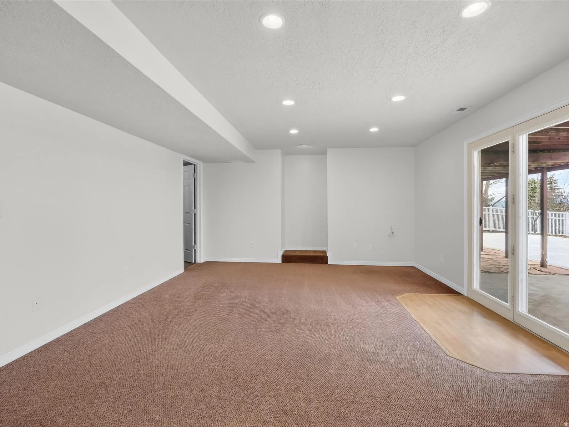 Unfurnished room with recessed lighting, light colored carpet, and a textured ceiling