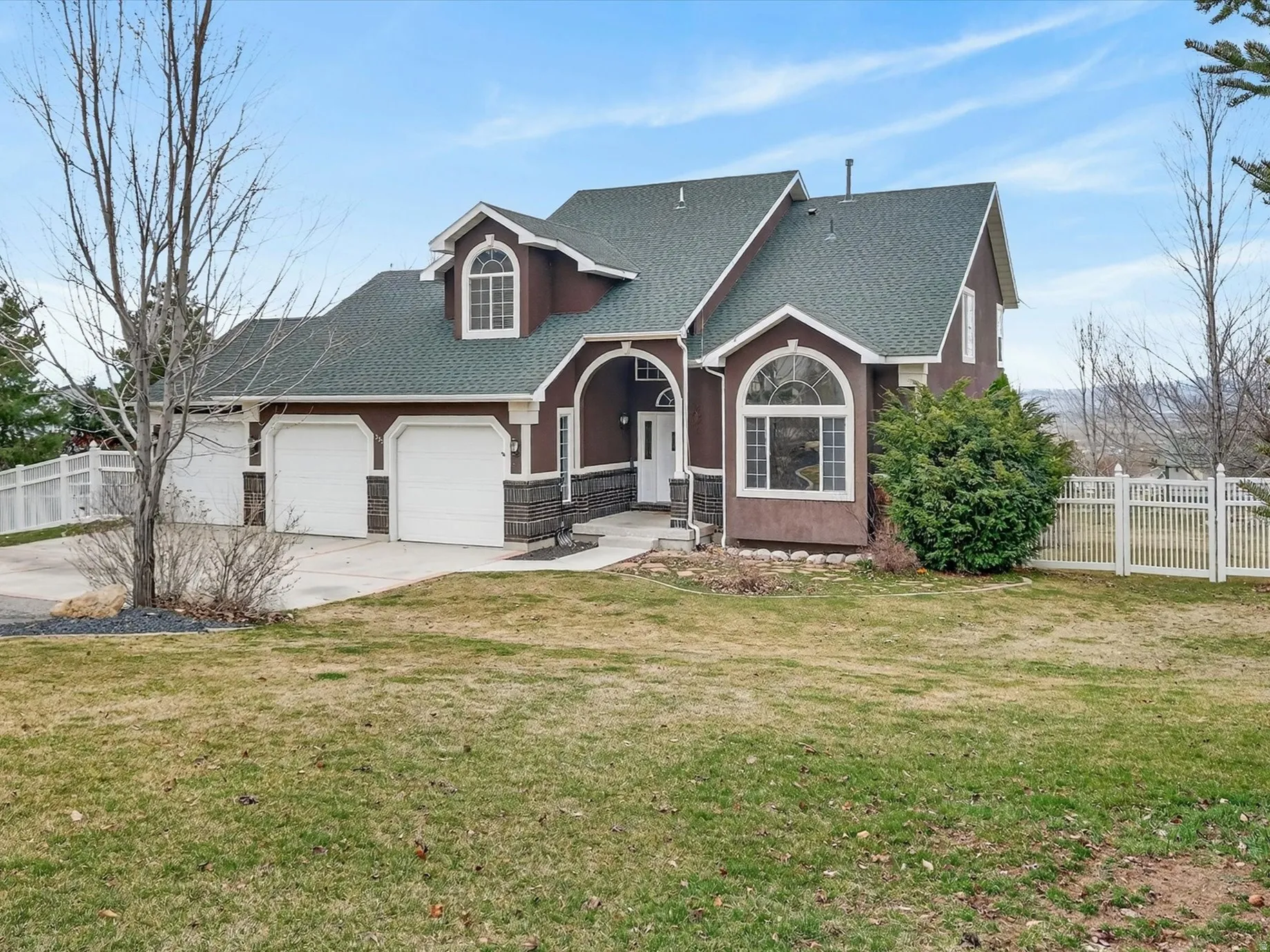 View of front of home with roof with shingles, concrete driveway, a garage, and stucco siding