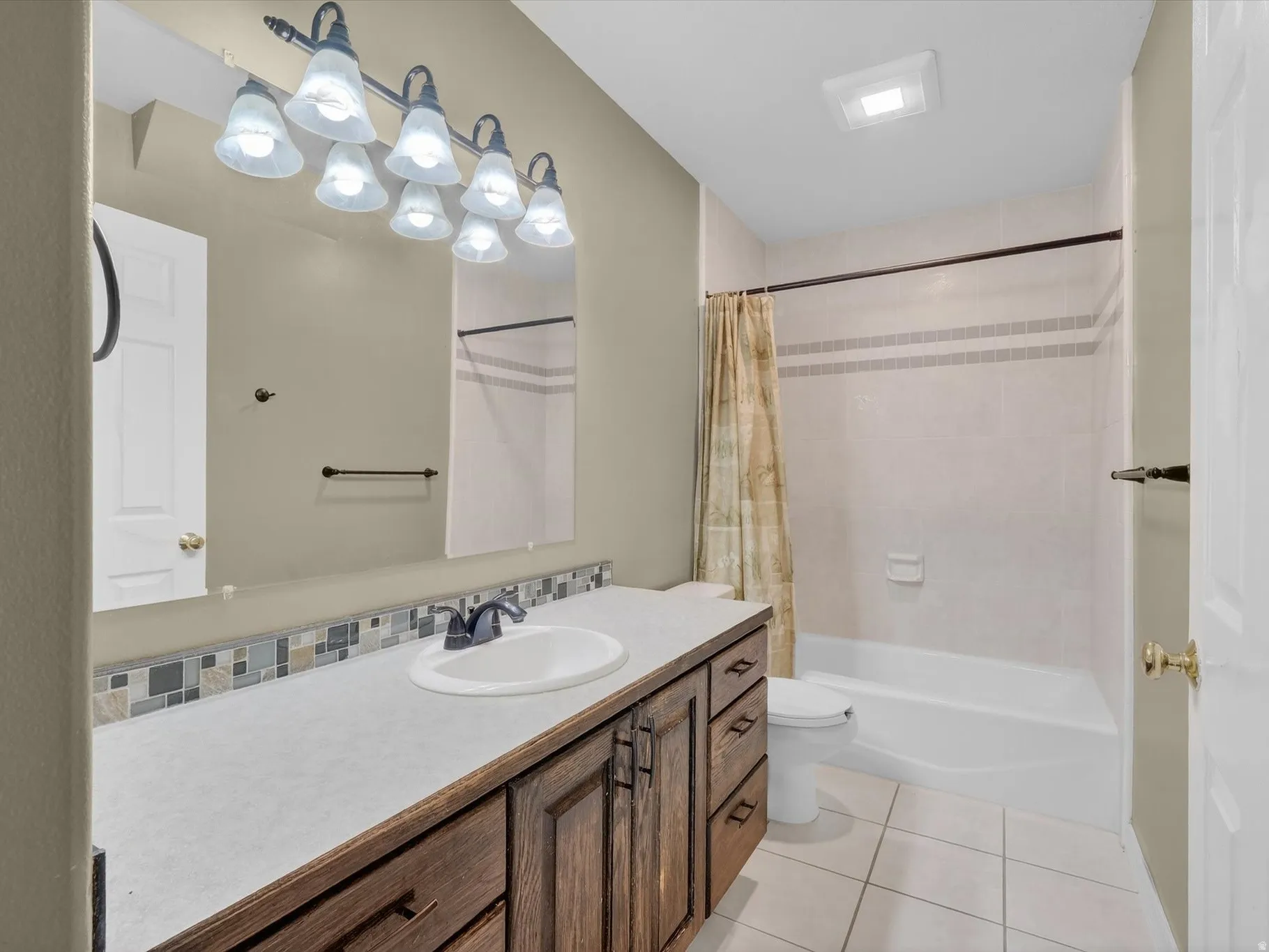 Bathroom with vanity, light tile patterned floors, and shower / bath combo