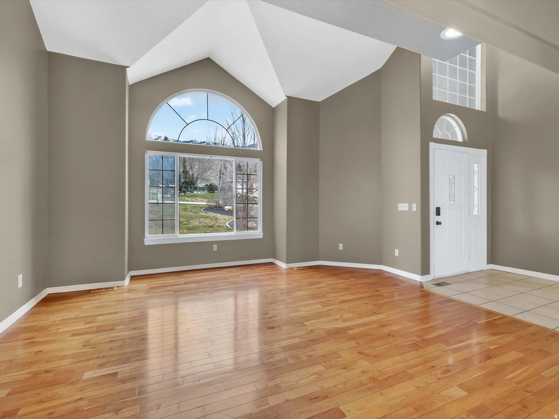 Entryway with vaulted ceiling and light wood-style floors