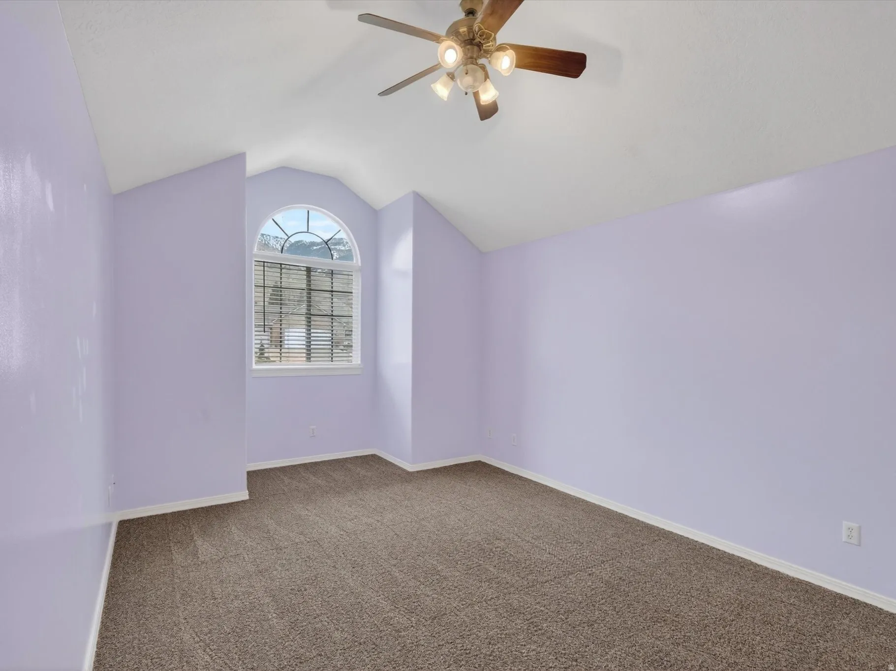Bonus room with dark carpet and a ceiling fan