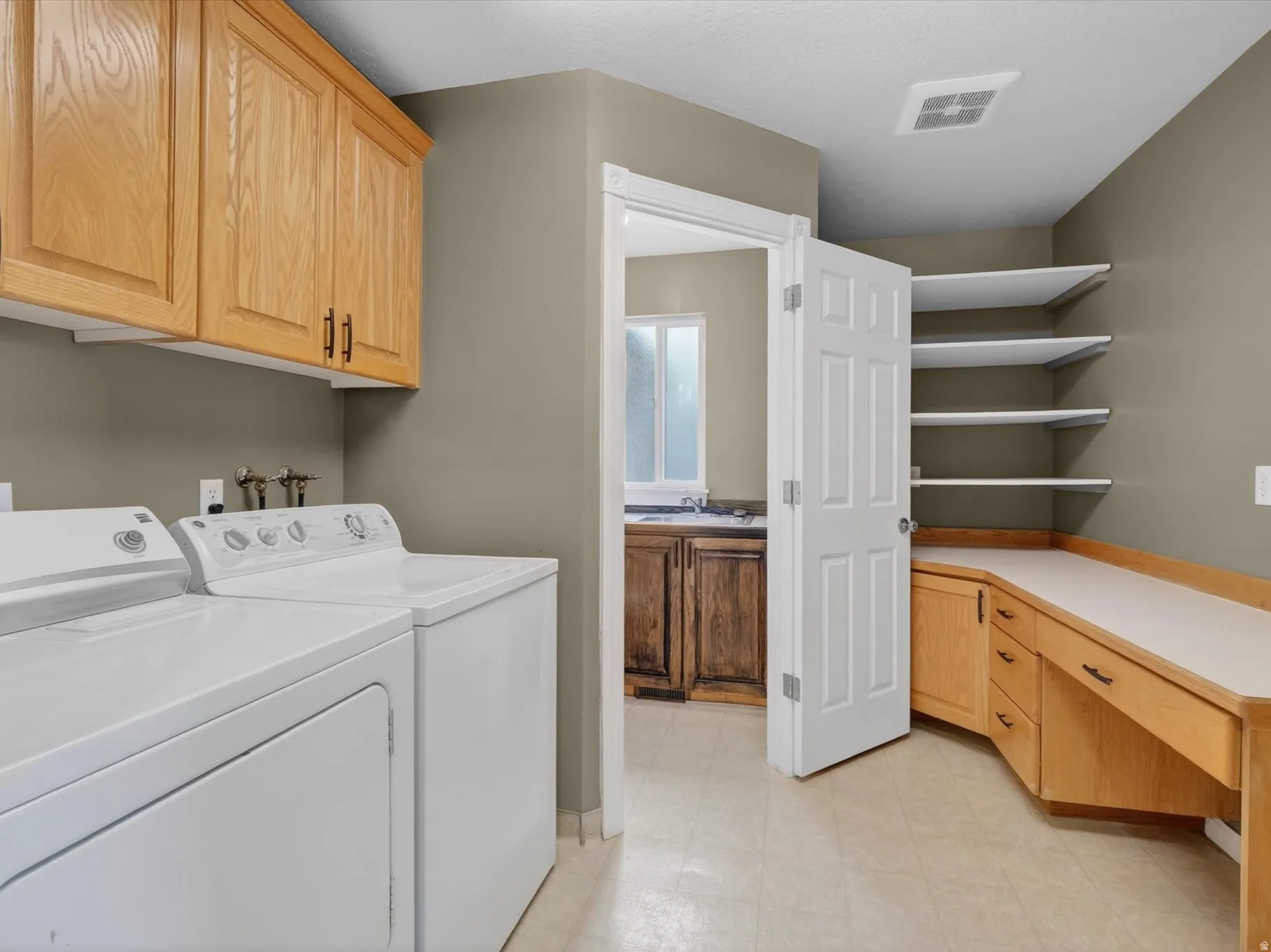 Laundry room with a desk, cabinet space, and washer and clothes dryer