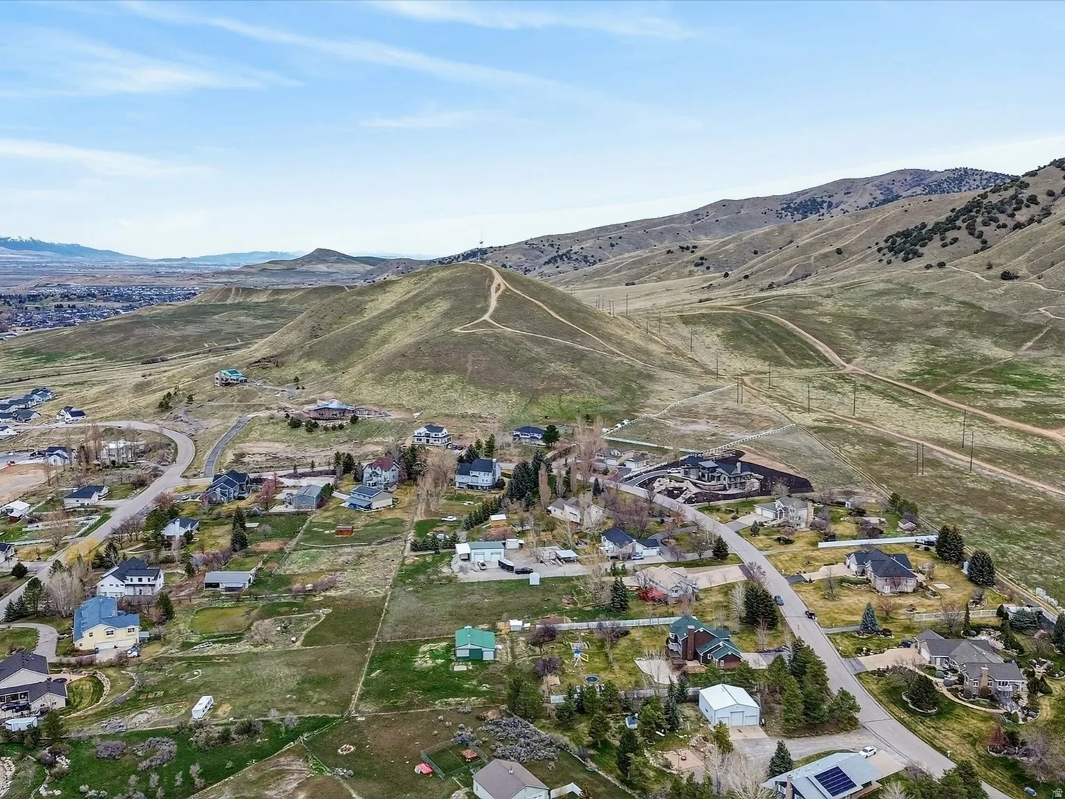 Aerial overview of property's location with nearby suburban area and mountains