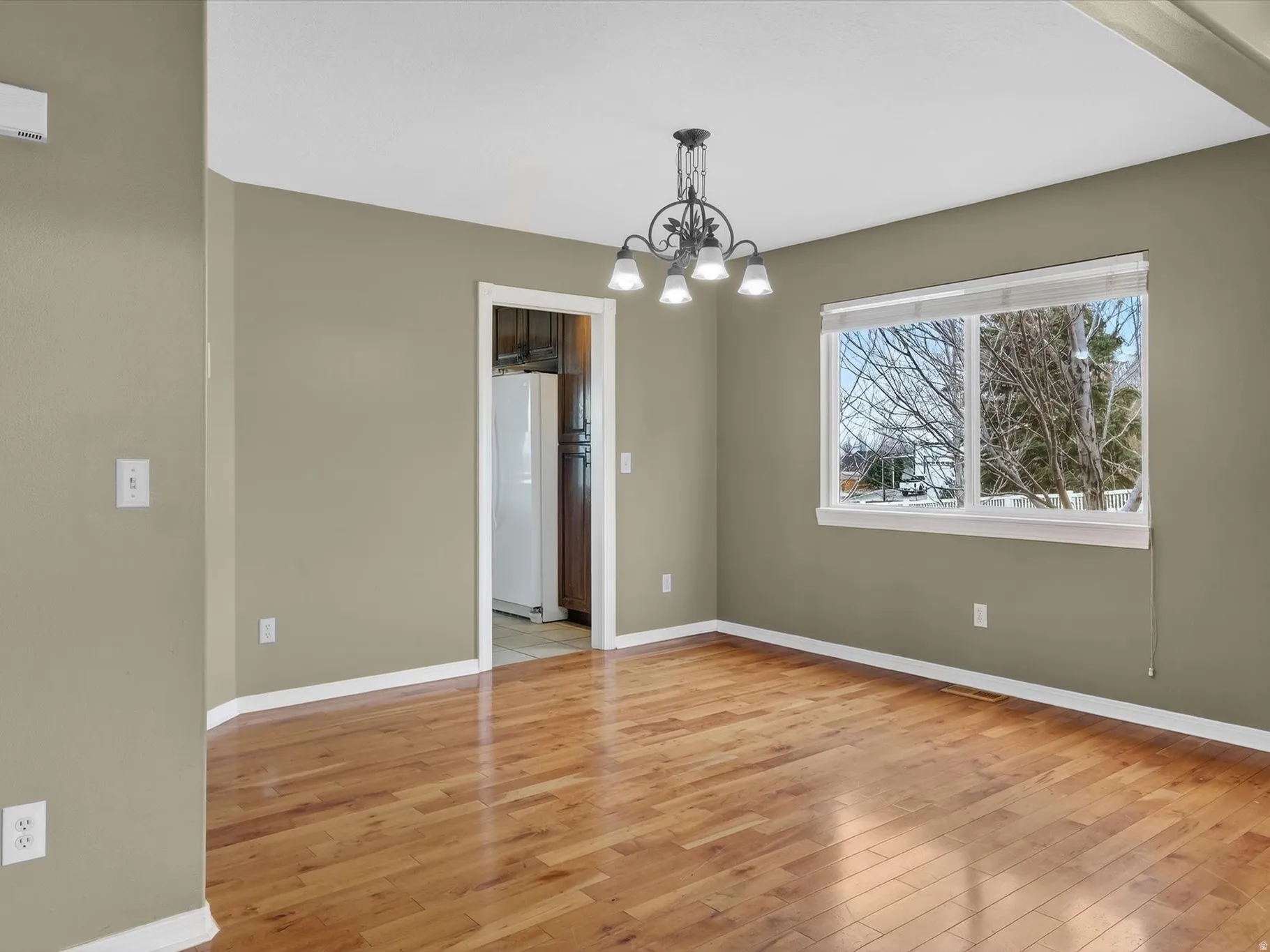 Unfurnished dining area with hanging lights and light wood-type flooring