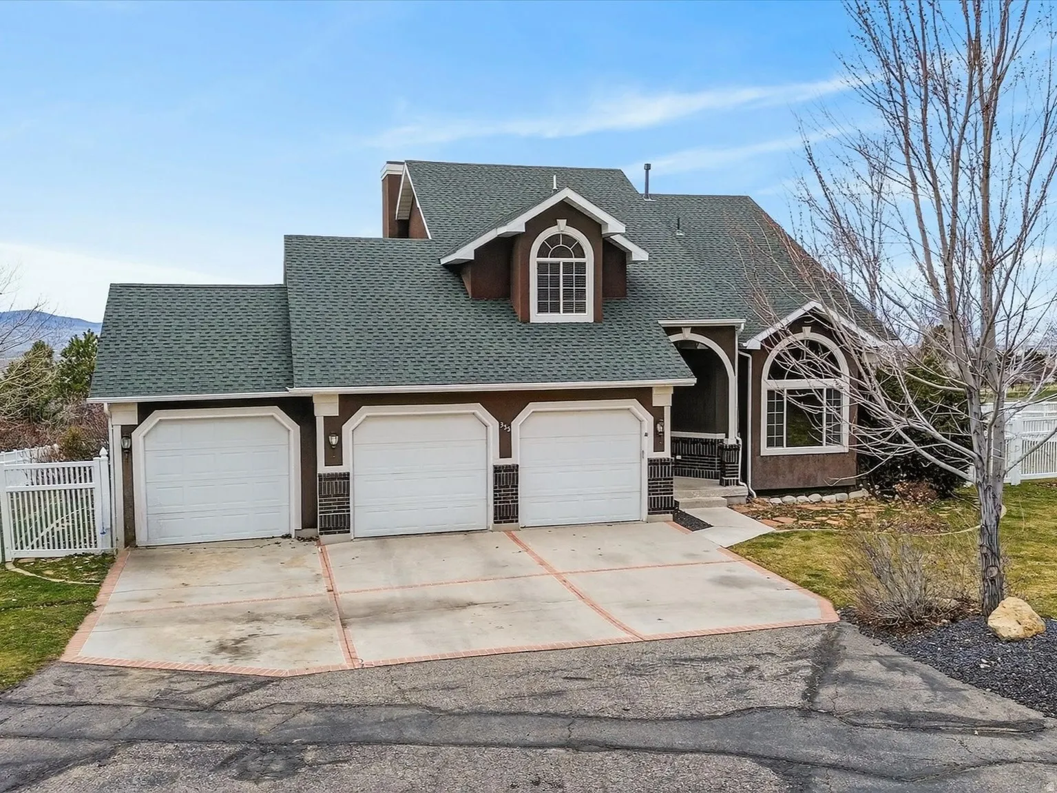 View of front of home featuring roof with shingles, a garage, and concrete driveway
