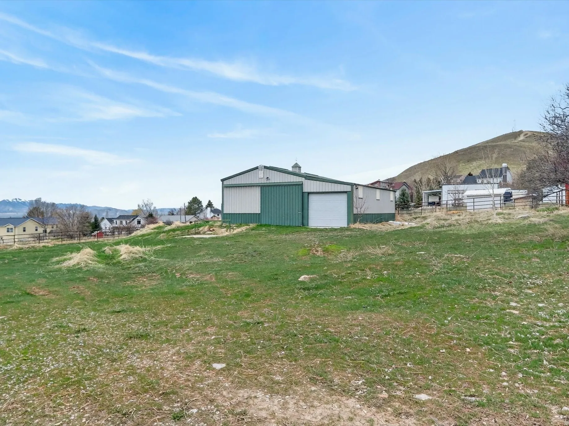 View of yard with a mountain view, an outdoor structure, a detached garage, and a pole building