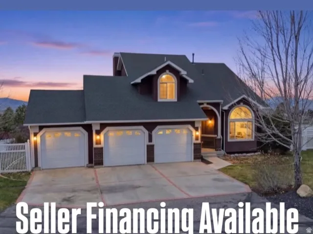 Two-story residence featuring a three-car garage, arched windows, and a covered entry