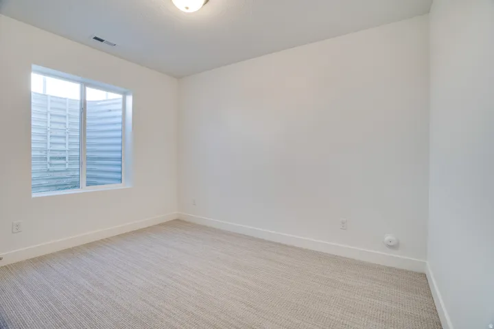 Empty room featuring light carpet and baseboards