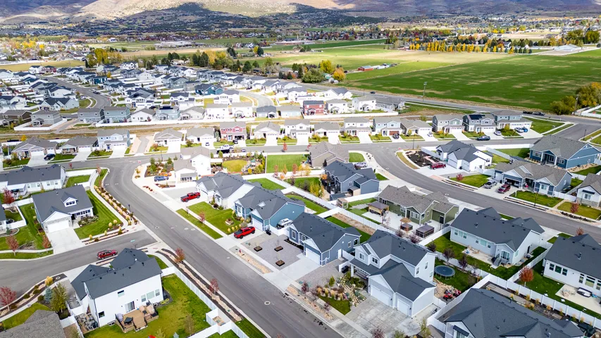 Aerial view of property and surrounding area featuring a mountainous background and nearby suburban area