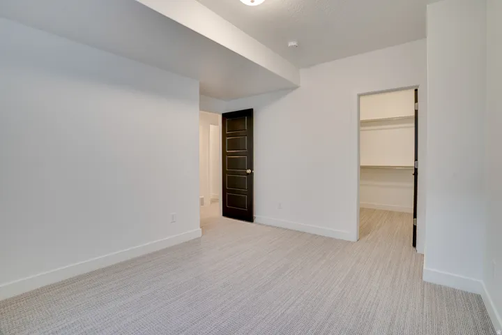 Empty room featuring light carpet and baseboards