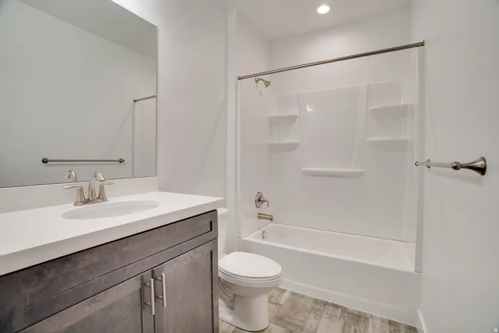Full bath with vanity, light wood-style flooring, shower / bathtub combination, and recessed lighting