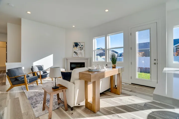 Living area featuring a glass covered fireplace, light wood-style flooring, and recessed lighting