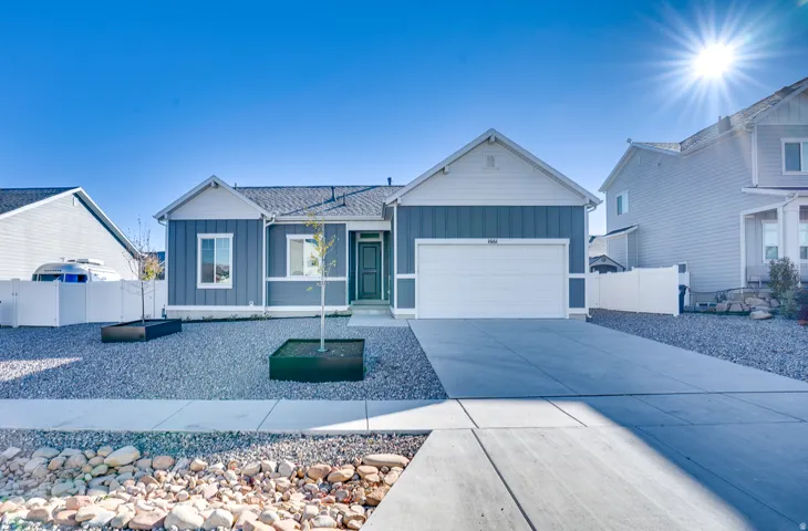 Ranch-style home featuring board and batten siding, driveway, and an attached garage
