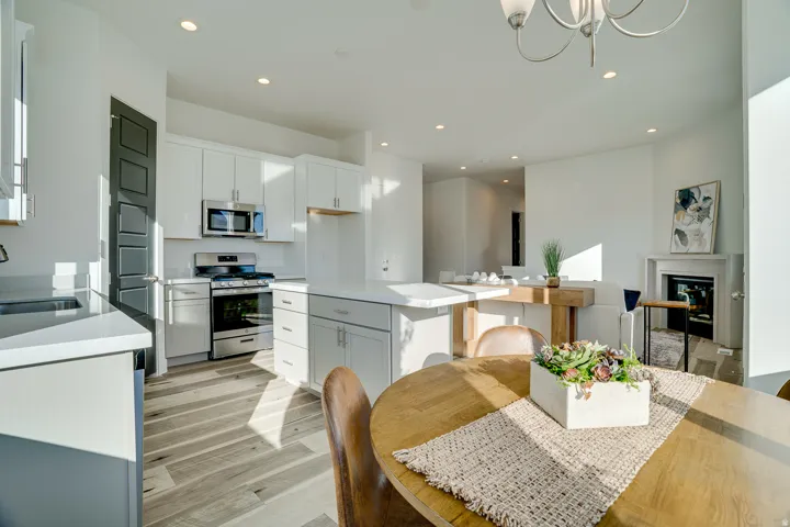 Kitchen featuring stainless steel appliances, light wood-type flooring, white cabinets, and a center island
