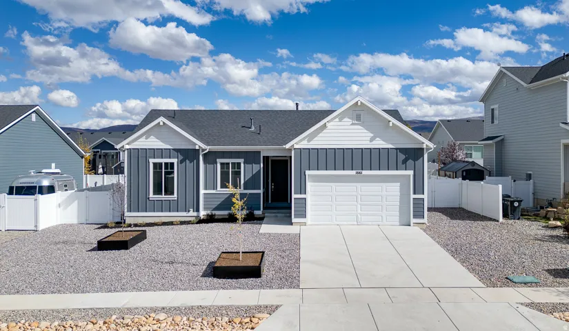 Ranch-style home featuring board and batten siding, driveway, a garage, and a residential view