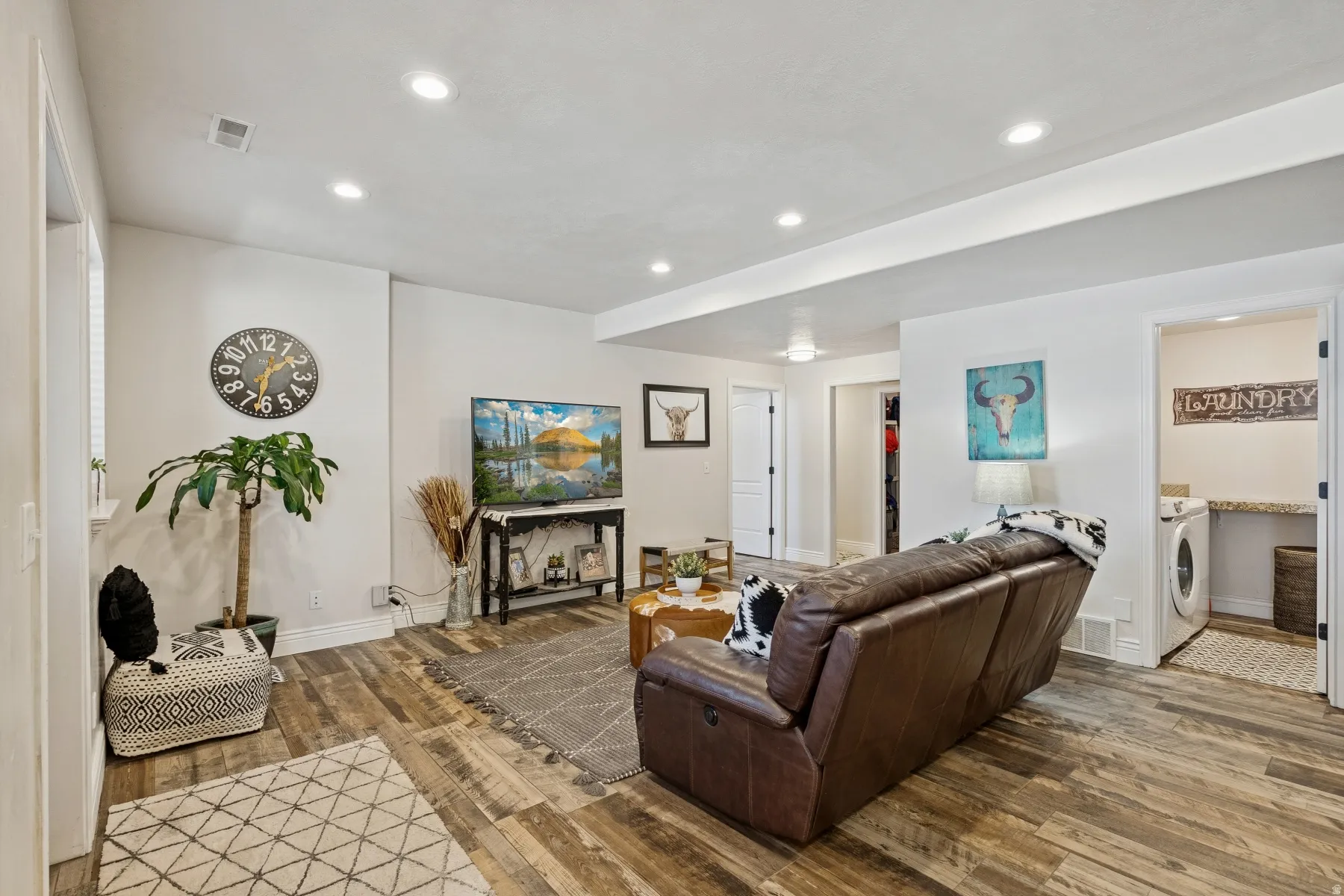 Living area with hardwood / wood-style floors, recessed lighting, and washer / dryer
