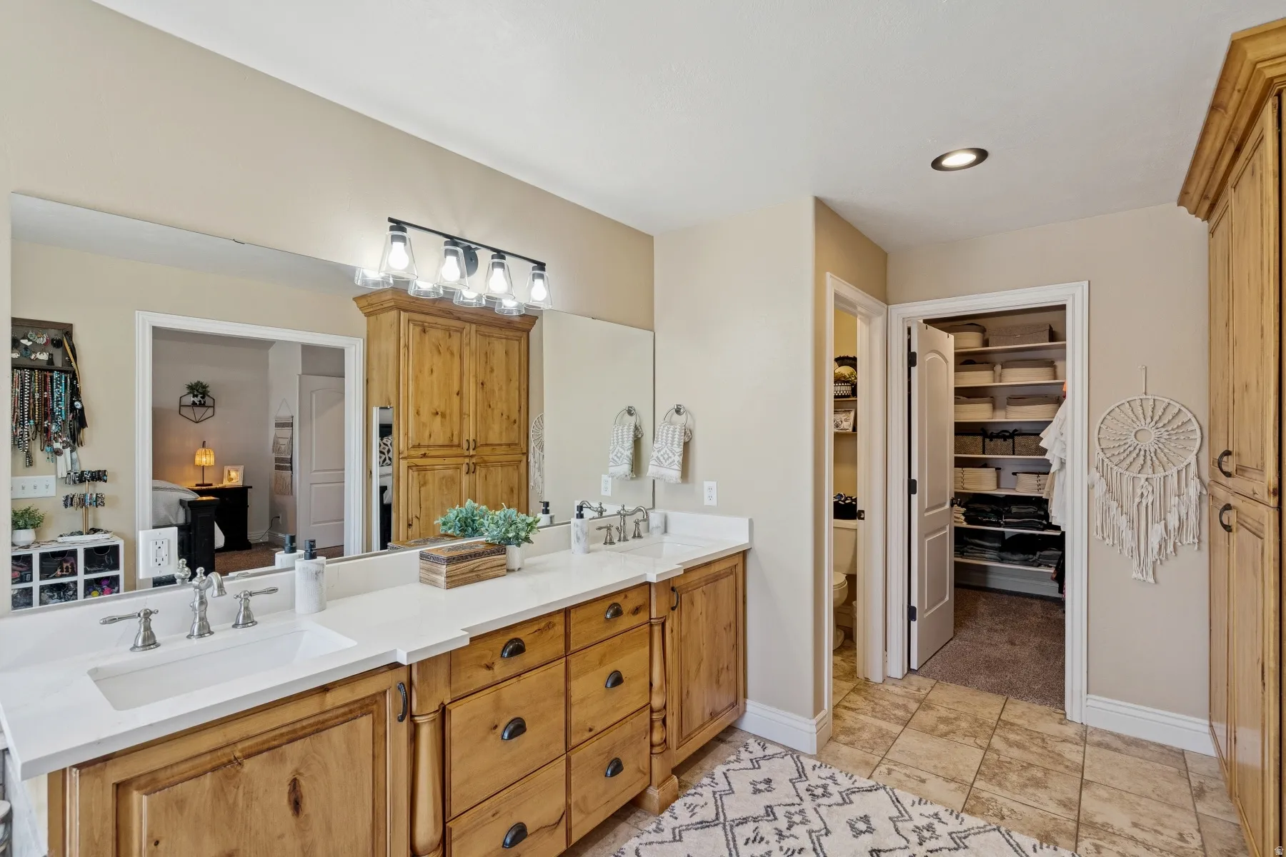 Ensuite bathroom with a spacious closet, double vanity, and recessed lighting