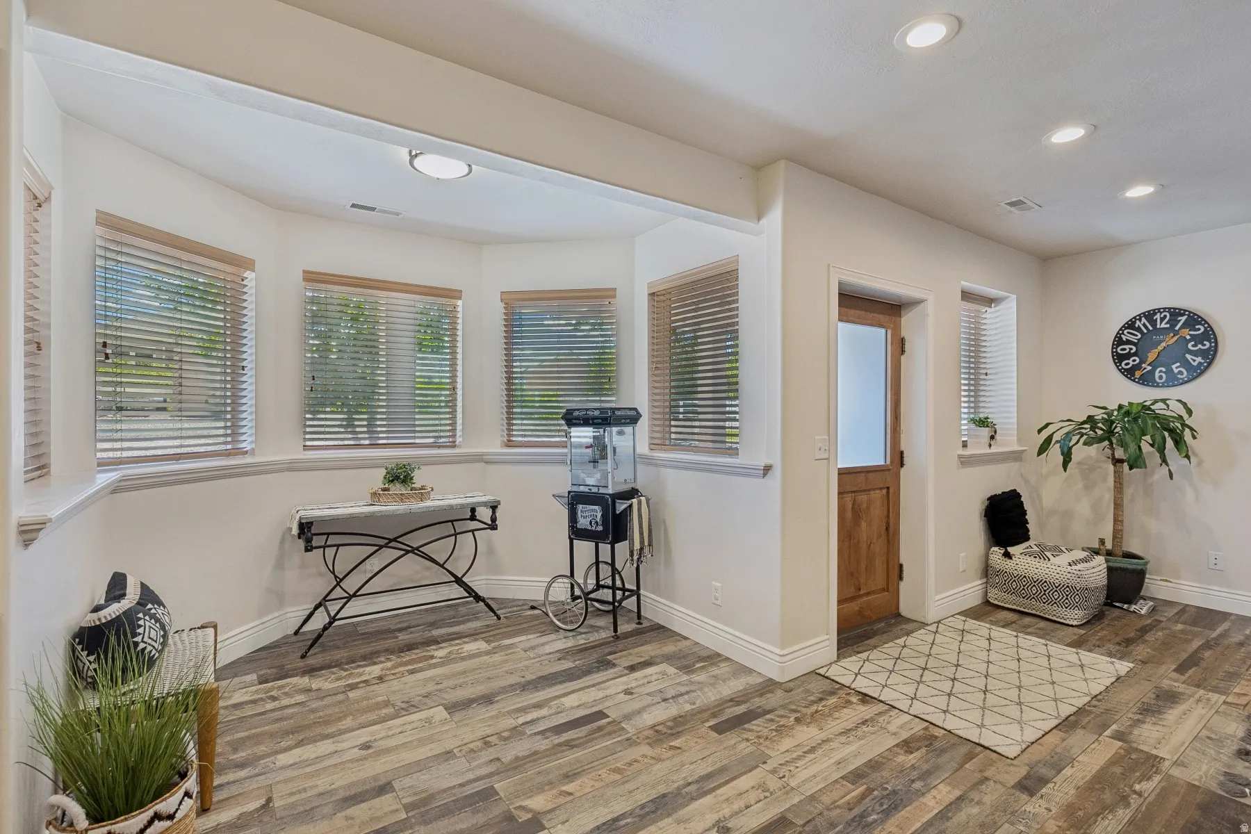 Sitting room with wood finished floors, plenty of natural light, and recessed lighting