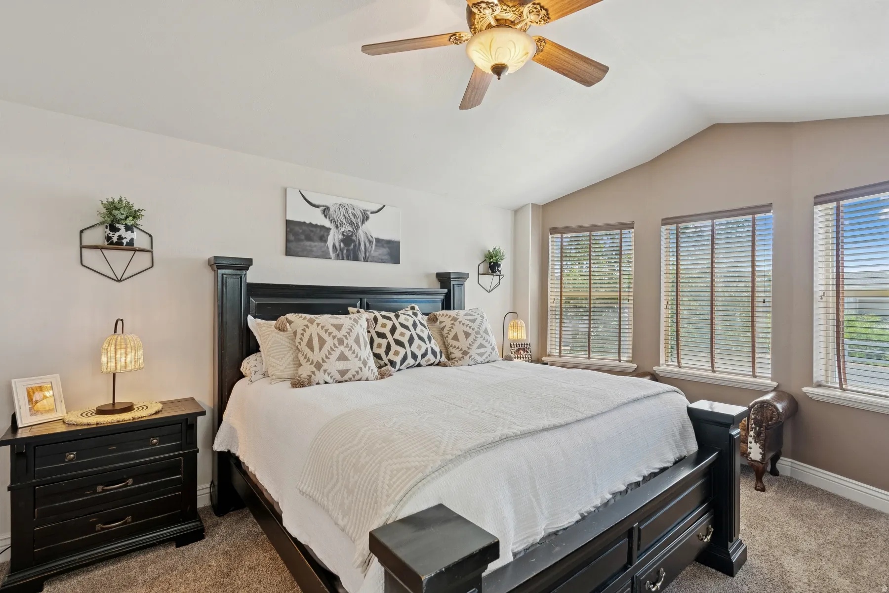 Bedroom with dark carpet, lofted ceiling, and a ceiling fan