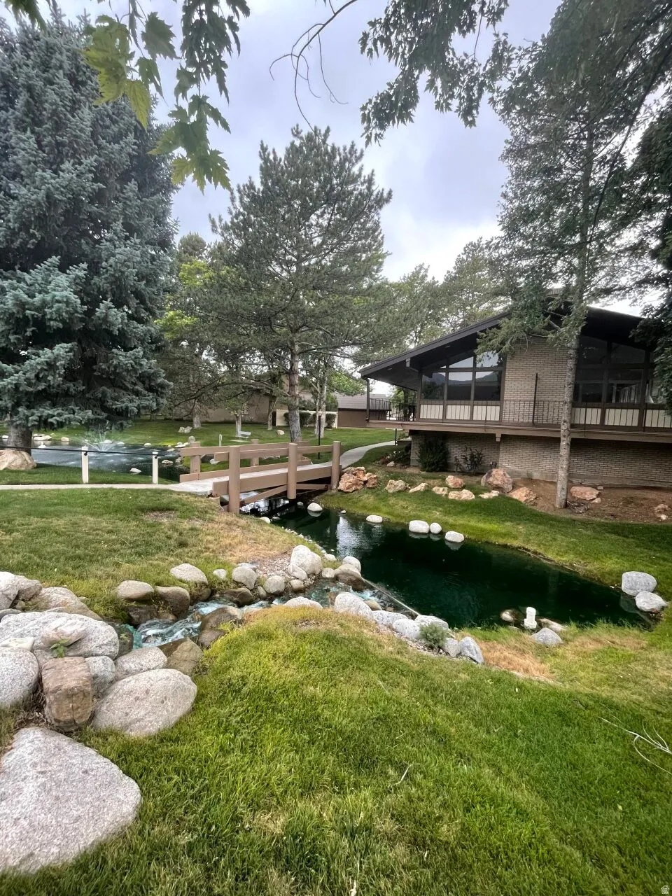 View of grassy yard featuring a deck and a sunroom