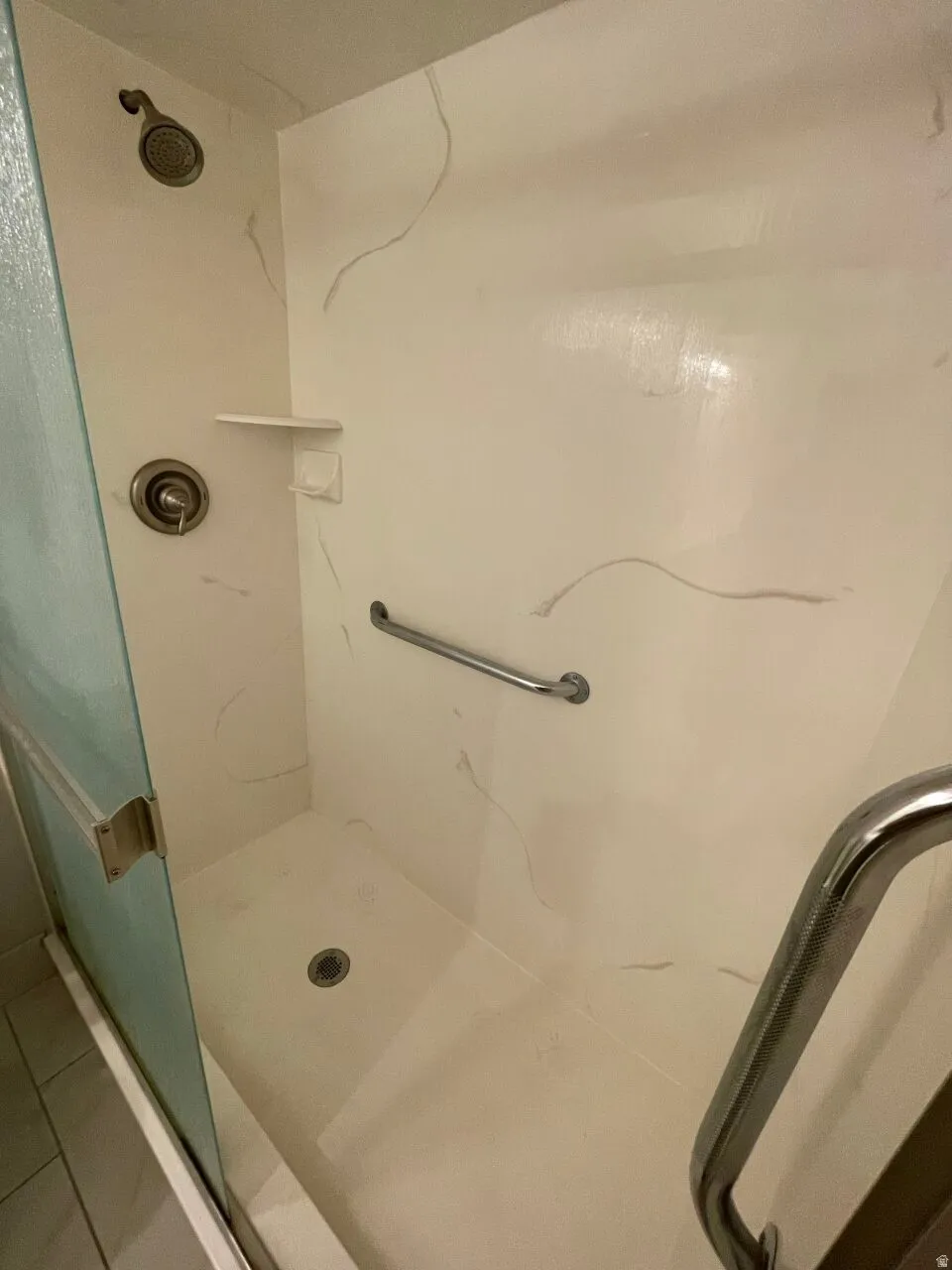 Bathroom featuring a walk in shower with rails