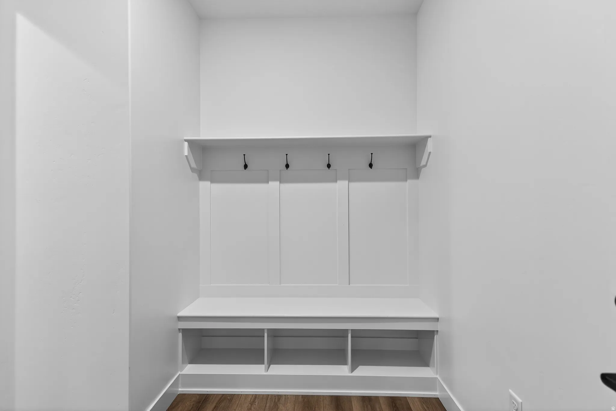 Mudroom featuring dark wood-type flooring and baseboards