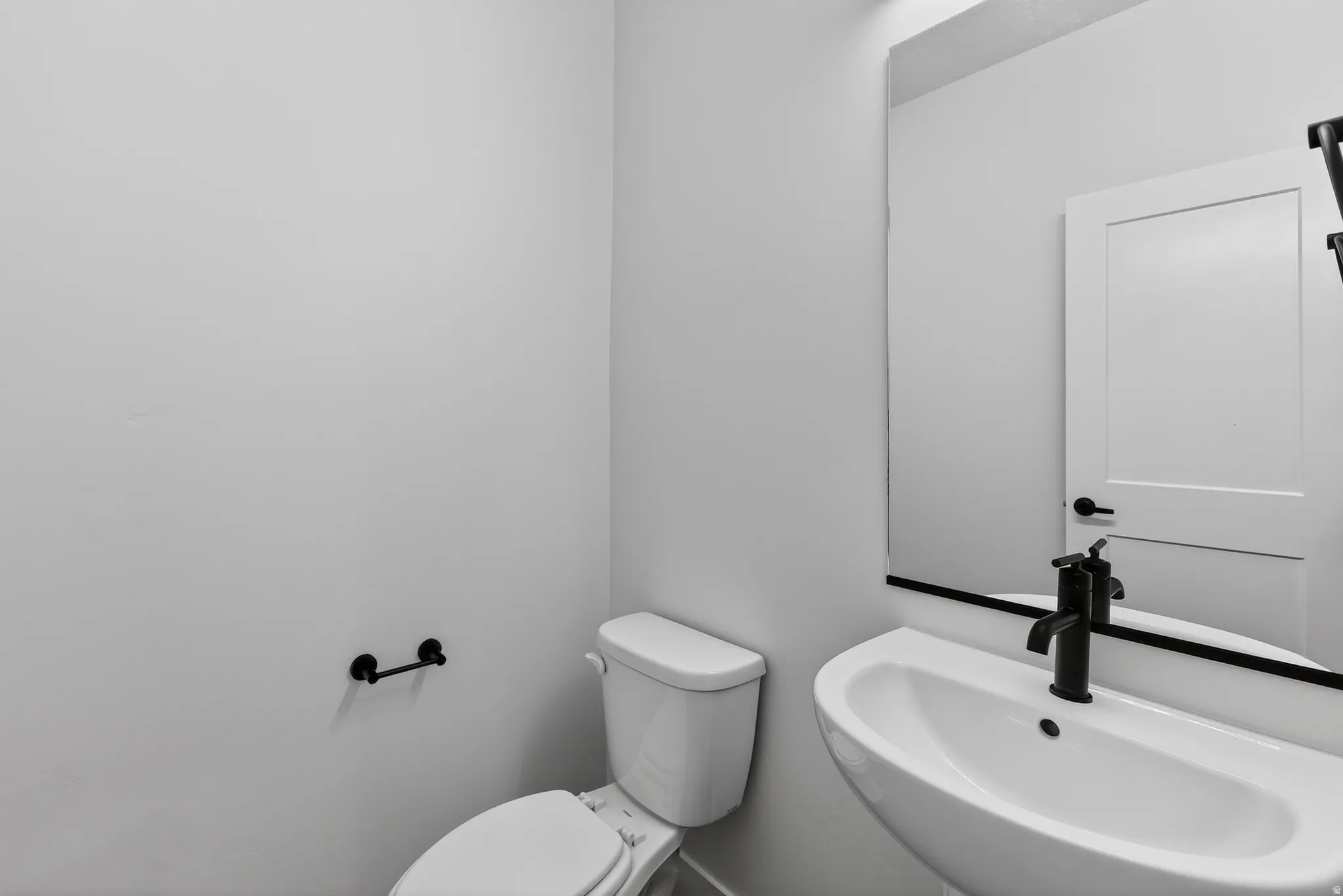 Half bathroom featuring toilet and a sink
