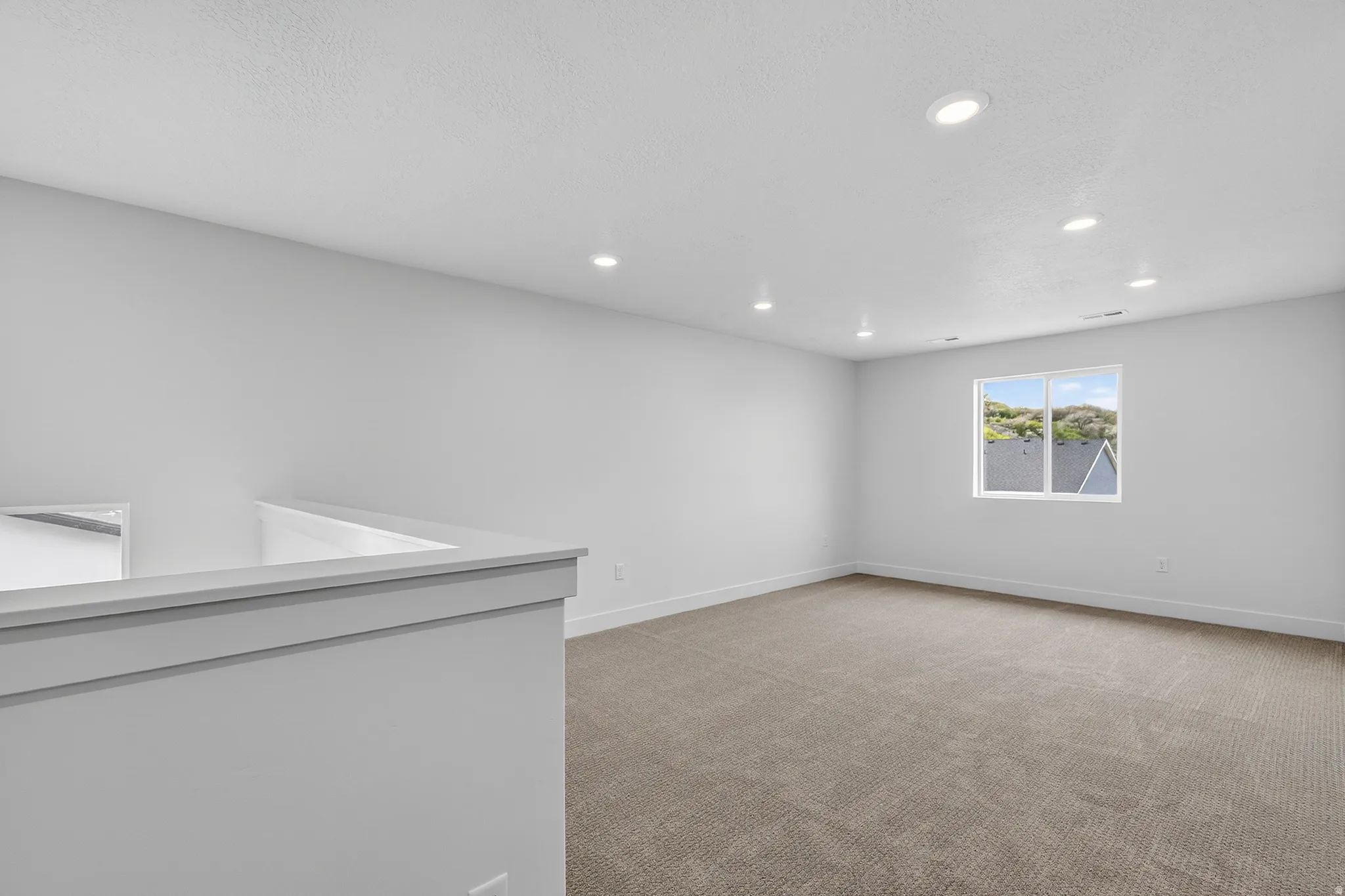 Spare room featuring light colored carpet and recessed lighting
