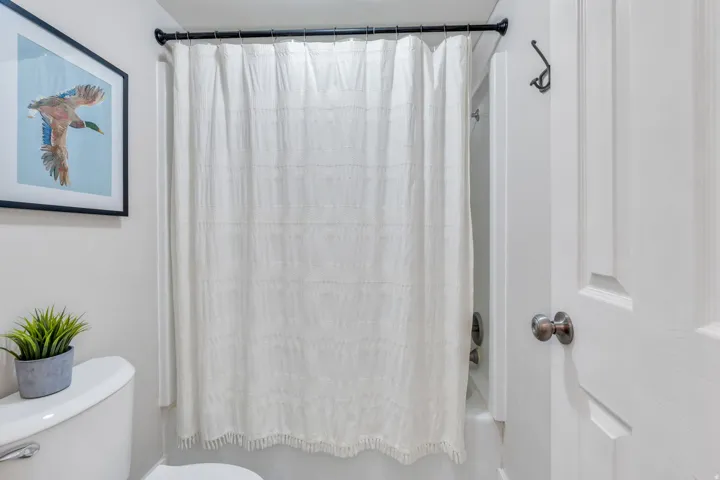 Bathroom with shower / bath combo with shower curtain and toilet