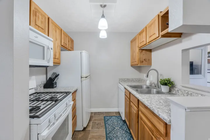 Kitchen featuring white appliances and pendant lighting