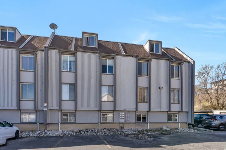 View of apartment building / complex featuring uncovered parking