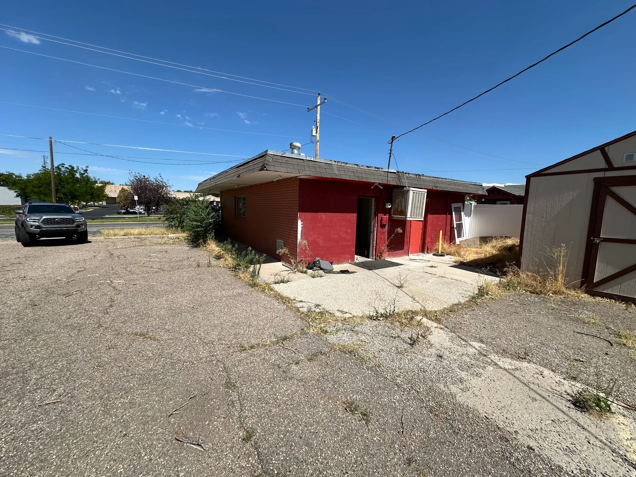 Rear view of house featuring brick siding and a storage shed