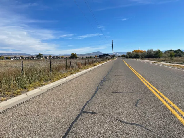 View of asphalt street featuring a mountain view and curbs