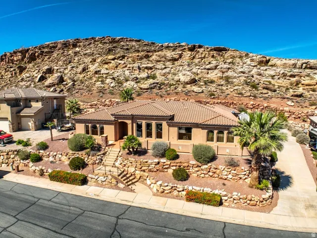Desert landscaping with mature foliage, stone retaining walls, and a multi-level terraced design