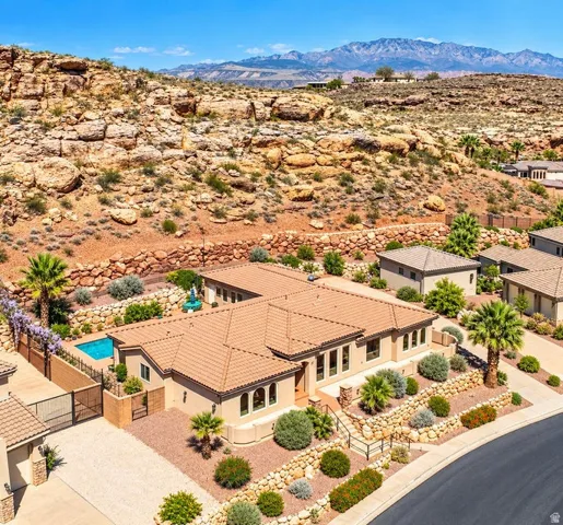 Terracotta tile roofing, stucco exterior, integrated swimming pool, desert landscaping, and a mountainous backdrop