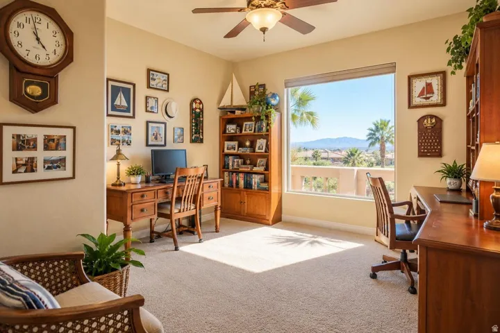 Large window, mountain backdrop, palm trees, ceiling fan, and carpeted flooring