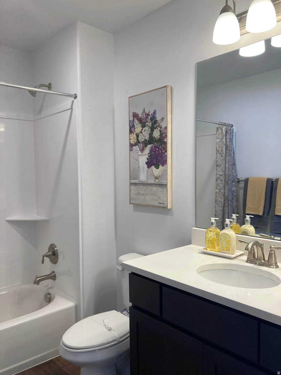MODEL Bathroom featuring vanity, shower / tub combo with curtain, and dark wood-style flooring