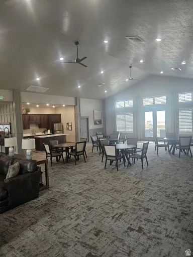 CLUBHOUSE Dining area with a high ceiling, ceiling fan, light colored carpet, and recessed lighting