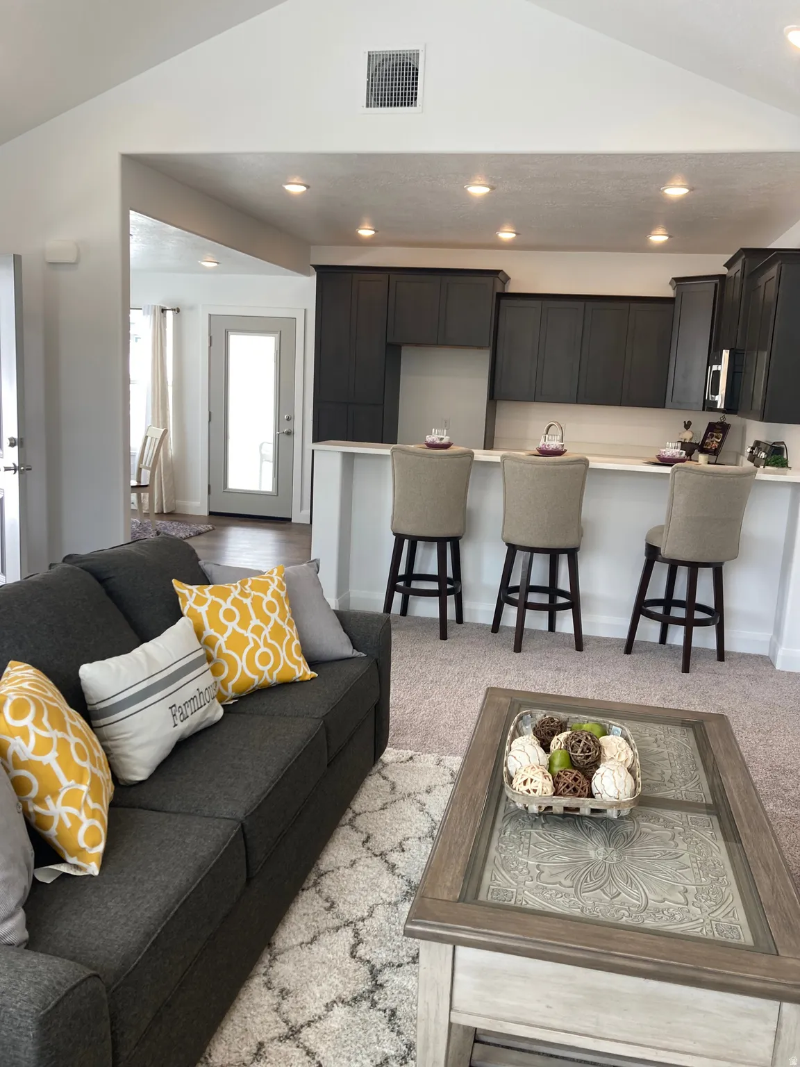 MODEL Living room with lofted ceiling, recessed lighting, and light colored carpet