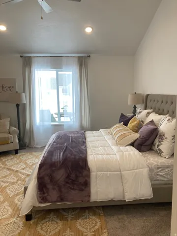 MODEL Carpeted bedroom with a ceiling fan and recessed lighting