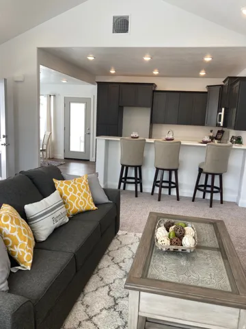 MODEL Living room with lofted ceiling, recessed lighting, and light colored carpet