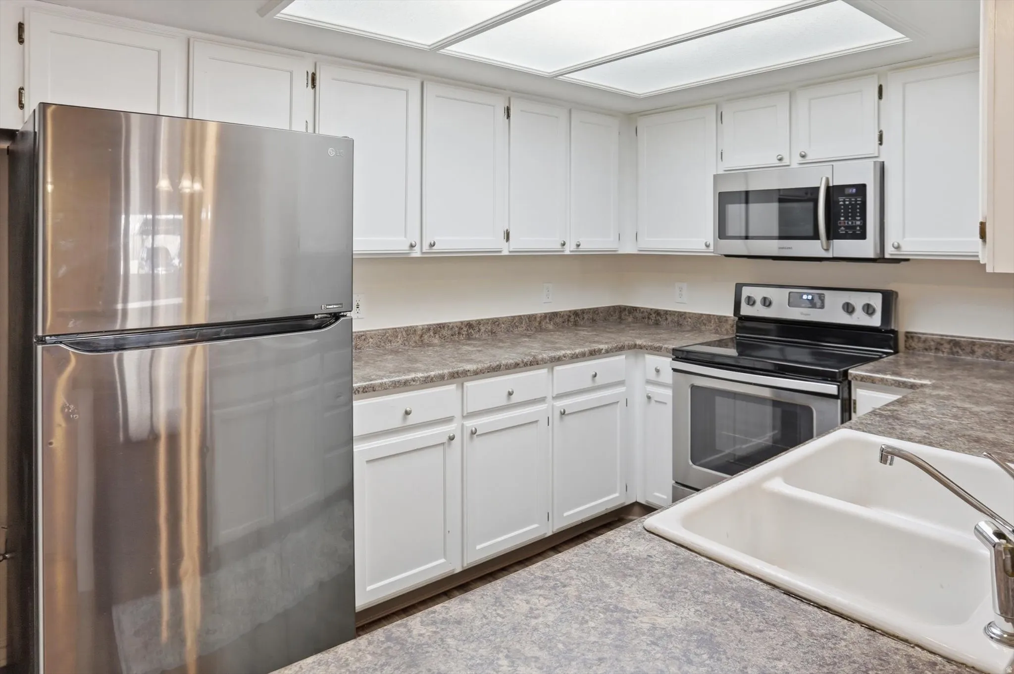 Kitchen with stainless steel appliances and white cabinetry